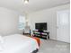 Well-lit bedroom features a bed with white linens, a TV, and a view of the neighborhood through the window at 4268 Coachwhip Ave, Lancaster, SC 29720