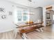 Bright dining room with wood table, bench, and white chairs with stairway in background at 4268 Coachwhip Ave, Lancaster, SC 29720