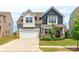 Inviting two-story home features a well-maintained lawn, stone accents, a two-car garage, and charming curb appeal at 4268 Coachwhip Ave, Lancaster, SC 29720