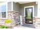 Charming front porch with stone accents, a cozy bench, a decorative sign and colorful flowers at 4268 Coachwhip Ave, Lancaster, SC 29720