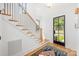 Bright entryway featuring a staircase with hardwood treads, black iron balusters, and a stylish front door at 4900 Doris Ave, Charlotte, NC 28205
