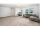 Spacious bonus room with multiple windows, neutral carpet and comfortable sectional couch at 5499 Angus Dr, Midland, NC 28107