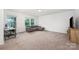 Large bonus room with great natural light, neutral carpet and a comfortable sectional couch at 5499 Angus Dr, Midland, NC 28107