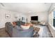 Inviting living room featuring a gray sectional sofa, wood floors, and bright natural lighting at 5499 Angus Dr, Midland, NC 28107
