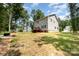 Large, grassy backyard of home with trees, deck and grill at 5499 Angus Dr, Stanfield, NC 28163
