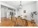 Bright dining area with modern glass table, hardwood floors, connecting to the kitchen and living room at 558 Oakland Ave, Charlotte, NC 28204
