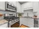 Modern kitchen featuring stainless steel appliances, white cabinetry, and granite countertops at 558 Oakland Ave, Charlotte, NC 28204