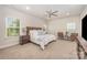 Spacious bedroom with a wood accent headboard, neutral color palette, and a ceiling fan at 7739 Village Pkwy, Locust, NC 28097