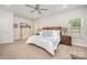 Bright primary bedroom with ample natural light, ceiling fan, and comfortable furniture at 7739 Village Pkwy, Locust, NC 28097