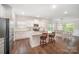 Open kitchen featuring a granite island, stainless steel appliances, and hardwood floors that extend into the dining area at 7739 Village Pkwy, Locust, NC 28097