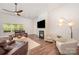 Comfortable living room featuring a fireplace, hardwood floors, ceiling fan, and stylish furnishings at 7739 Village Pkwy, Locust, NC 28097