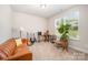 Versatile living room with a comfortable leather sofa and ample natural light, perfect for relaxation or entertaining at 7739 Village Pkwy, Locust, NC 28097