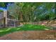 Lush backyard with a wooden fence, green lawn, and a charming screened porch at 807 Water Wheel Ct, Charlotte, NC 28209