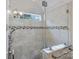 Nicely tiled shower with glass door, shower seat, and horizontal accent tile at 807 Water Wheel Ct, Charlotte, NC 28209