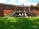 Exterior brick home showing a backyard with a deck and green grass at 814 Aileen Cir, Pineville, NC 28134