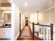 Hallway with hardwood floors, a staircase, and views of a bathroom with tiled floors at 841 16Th Avenue Nw Ln, Hickory, NC 28601