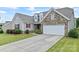 Attractive single-Gathering home with a manicured lawn, stone accents, and attached two-car garage at 9547 Horsebit Ln, Concord, NC 28027