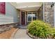 Inviting front porch with stone accents, a maroon front door, and a well-maintained garden bed at 9547 Horsebit Ln, Concord, NC 28027