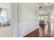 Hallway showcasing hardwood floors, decorative wainscoting, and a glimpse into the living space at 9547 Horsebit Ln, Concord, NC 28027