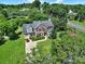 Aerial view of a beautiful home with lush greenery, a driveway, and mature trees at 9800 Ashley Farm Dr, Matthews, NC 28105