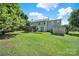 Lush backyard with mature trees, shed, well-kept lawn, and deck, perfect for outdoor activities at 9800 Ashley Farm Dr, Matthews, NC 28105