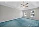 Large bedroom featuring ample natural light, a ceiling fan, and plush blue carpeting at 9800 Ashley Farm Dr, Matthews, NC 28105