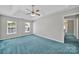 Spacious bedroom with tray ceiling, fan, light-filled windows and comfortable blue carpet at 9800 Ashley Farm Dr, Matthews, NC 28105