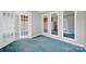 Bonus room featuring blue carpet, glass paneled doors, and a mirrored wall reflecting the space at 9800 Ashley Farm Dr, Matthews, NC 28105