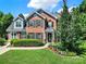 Inviting brick home with black shutters and lush front yard landscaping, offering great curb appeal at 9800 Ashley Farm Dr, Matthews, NC 28105