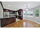 Well-appointed kitchen featuring dark wood cabinets, stainless steel appliances, and hardwood floors at 9800 Ashley Farm Dr, Matthews, NC 28105