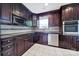 Elegant kitchen features dark cabinetry, stainless steel appliances, and tile backsplash at 9800 Ashley Farm Dr, Matthews, NC 28105