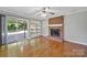 Bright living room features a brick fireplace, hardwood floors, and sliding doors to the backyard at 9800 Ashley Farm Dr, Matthews, NC 28105