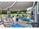 Charming back patio features comfortable seating under an awning, overlooking a lush, landscaped yard at 103 Pamlico Ln, Mooresville, NC 28117