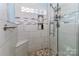 Modern tiled shower featuring a built-in seat, niche, and decorative accent tiles at 103 Pamlico Ln, Mooresville, NC 28117