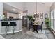 Open-concept dining area with modern table set and adjacent breakfast bar to the kitchen at 103 Pamlico Ln, Mooresville, NC 28117