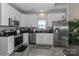 Well-equipped kitchen with stainless steel appliances, granite countertops, and white cabinets for a modern look at 103 Pamlico Ln, Mooresville, NC 28117
