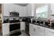 Updated kitchen featuring white cabinetry, stainless steel appliances, and black countertops for a stylish look at 103 Pamlico Ln, Mooresville, NC 28117