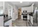 Modern kitchen boasting white cabinets, stainless steel appliances, and access to other areas of the home at 103 Pamlico Ln, Mooresville, NC 28117