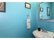 Charming powder room with blue walls, a stylish sink, and decorative accents at 103 Pamlico Ln, Mooresville, NC 28117