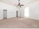 Spacious bedroom with neutral carpet, large window, ceiling fan, and ample closet space at 110 College St, Marshville, NC 28103