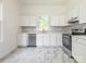 Kitchen with white cabinets, stainless steel appliances, gray subway tile backsplash and marble floors at 110 College St, Marshville, NC 28103