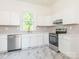 Modern kitchen with stainless steel appliances, white cabinets, and gray subway tile backsplash at 110 College St, Marshville, NC 28103