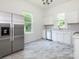 Bright kitchen with stainless steel appliances, white cabinets, and marble tile floor at 110 College St, Marshville, NC 28103