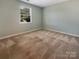A spare bedroom has a window that lets in natural light and neutral carpeting at 1332 Kings Grove Dr # Lot 18, York, SC 29745