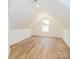Spacious attic room with wood-look flooring, a recessed light, and a window at 135 Brookview Dr, Shelby, NC 28152