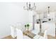 Dining room with modern chandelier, glass table, and open to the kitchen with stainless steel appliances at 135 Brookview Dr, Shelby, NC 28152