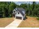 Eye-level shot of the house and driveway, with lots of trees at 135 Brookview Dr, Shelby, NC 28152