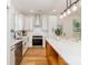 Kitchen featuring an island with seating, stainless steel appliances, white cabinets, and hardwood flooring at 135 Brookview Dr, Shelby, NC 28152
