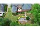 Aerial view of a brick home featuring mature landscaping, an outdoor seating area and a fire pit at 13824 Glen Abbey Dr, Charlotte, NC 28278