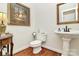 Powder room with pedestal sink, toilet, framed mirror, and beautiful hardwood floors at 13824 Glen Abbey Dr, Charlotte, NC 28278